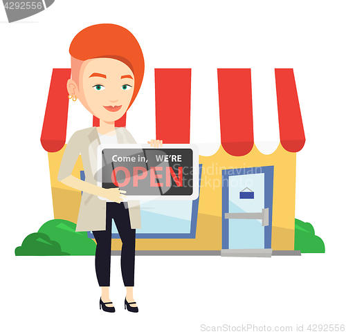 Image of Female shop owner holding open signboard.