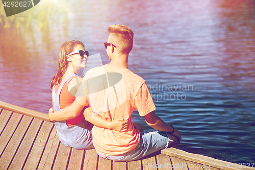 Image of happy teenage couple hugging on river berth