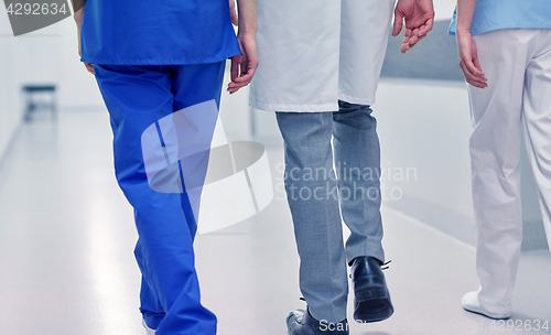 Image of group of medics or doctors walking along hospital