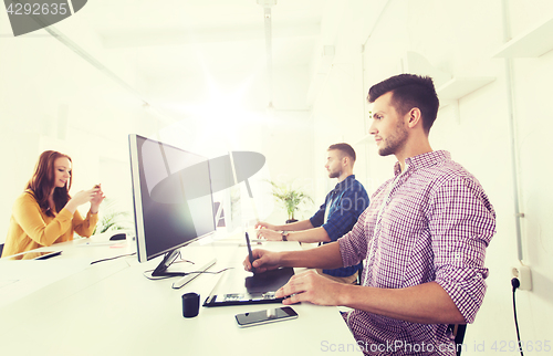 Image of man or designer with computer and tablet at office