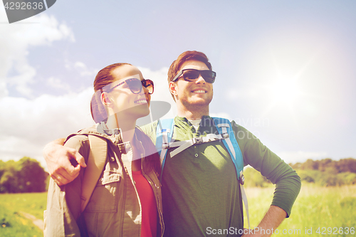 Image of happy couple with backpacks hiking outdoors