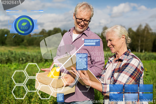 Image of senior couple with box of vegetables at farm