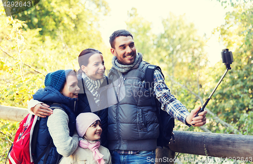 Image of family with backpacks taking selfie and hiking