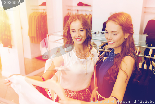 Image of happy women with shopping bags at clothing shop