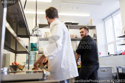 Image of chef and cook cooking food at restaurant kitchen