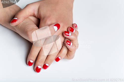 Image of Female hands with red and white nails