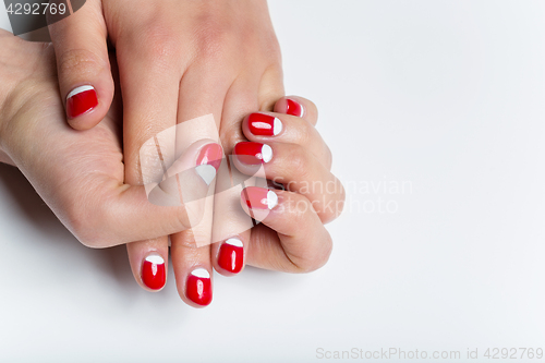 Image of Female hands with red and white nails