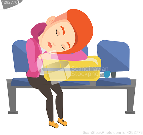 Image of Exhausted woman sleeping on suitcase at airport.