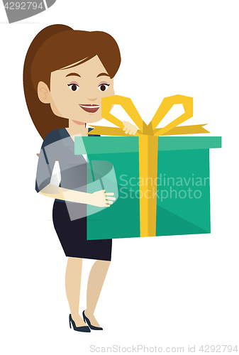 Image of Joyful caucasian woman holding box with gift.