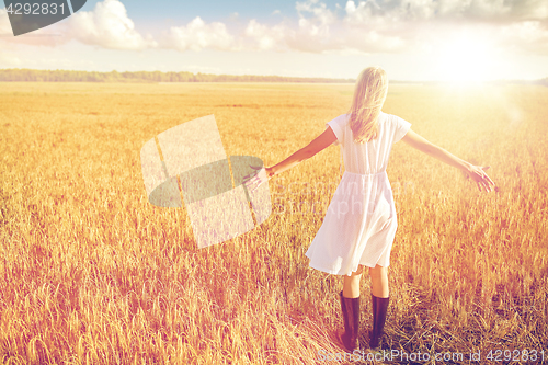 Image of happy young woman in white dress on cereal field