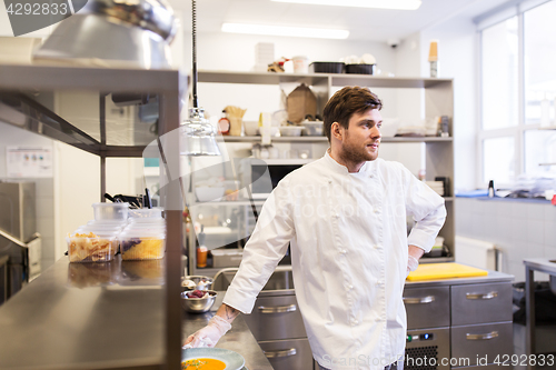 Image of happy male chef cooking food at restaurant kitchen