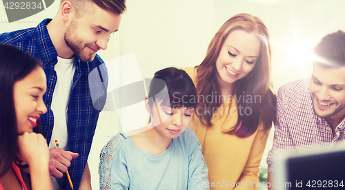 Image of happy creative team or students working at office