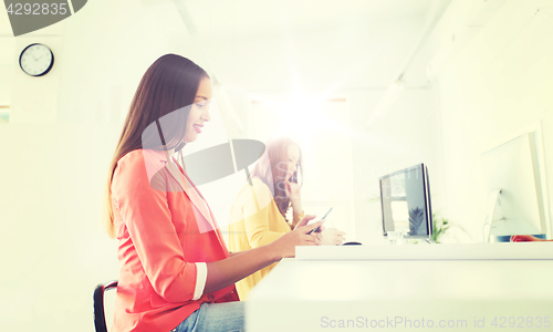 Image of businesswoman texting on smartphone at office