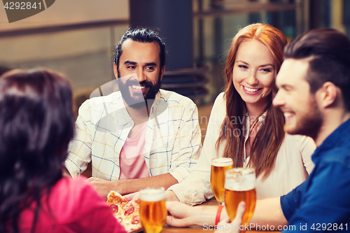 Image of friends eating pizza with beer at restaurant