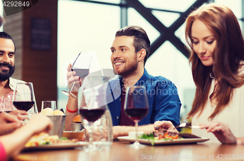 Image of friends dining and drinking wine at restaurant