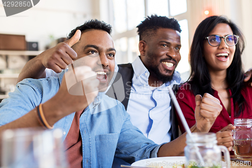 Image of happy fans or friends at bar or restaurant