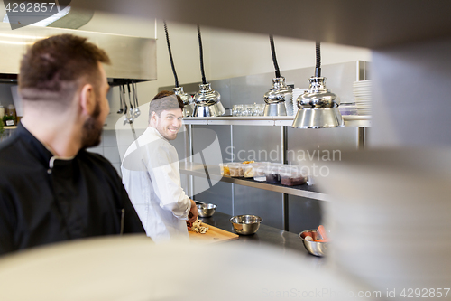 Image of chef and cook cooking food at restaurant kitchen