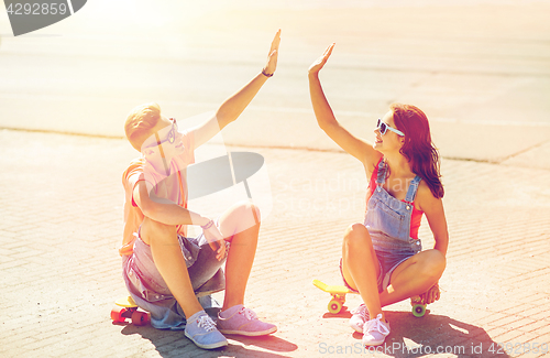 Image of teenage couple with skateboards on city street