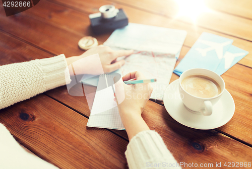 Image of close up of traveler hands with notepad and pencil