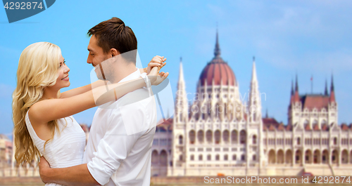 Image of happy couple over house of parliament in budapest