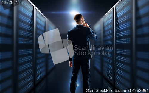 Image of businessman over server room background