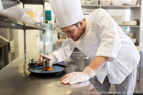 Image of happy male chef cooking food at restaurant kitchen