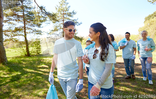 Image of volunteers with garbage bags talking outdoors