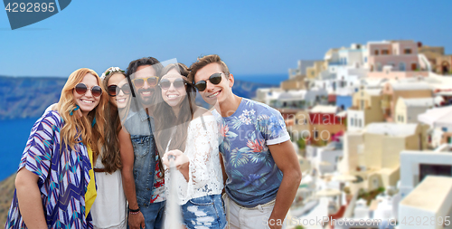 Image of happy hippie friends taking selfie on santorini