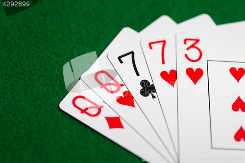 Image of poker hand of playing cards on green casino cloth