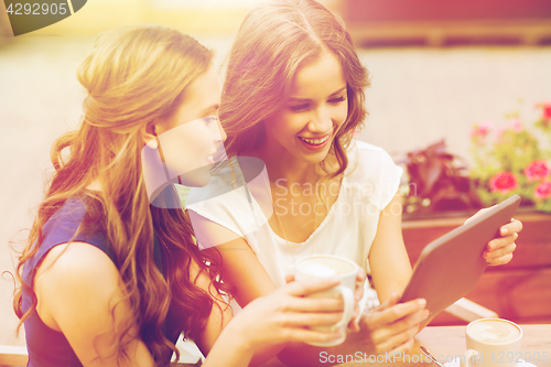 Image of young women with tablet pc and coffee at cafe