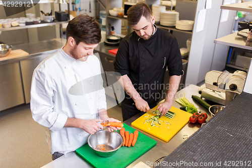 Image of happy male chef cooking food at restaurant kitchen