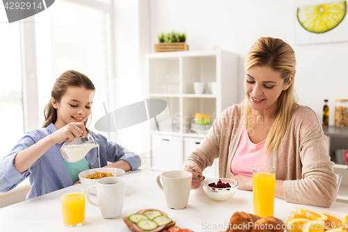 Image of happy family having breakfast at home kitchen