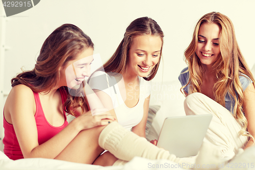 Image of happy friends or teen girls with tablet pc at home