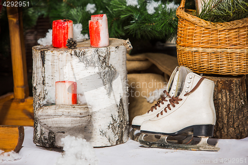 Image of Vintage ice skates for figure skating with fir tree branch hanging on rustic background.