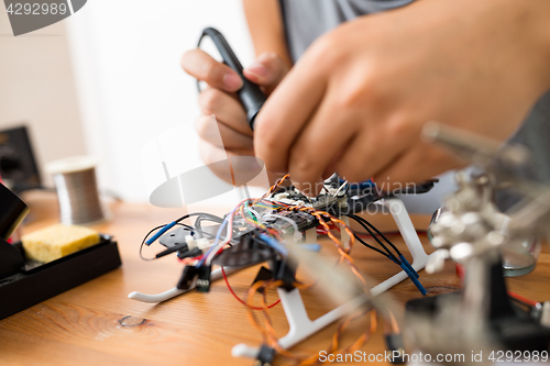 Image of Welding the wire on drone at home