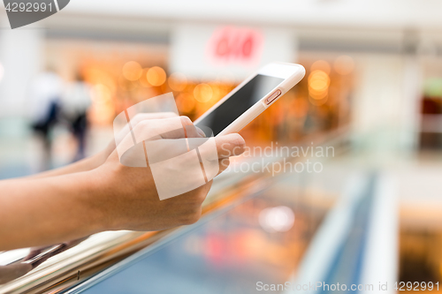 Image of Woman use of mobile phone in shopping mall