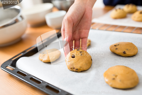 Image of Woman putting paste on metal tray