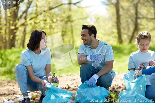 Image of volunteers with garbage bags cleaning park area