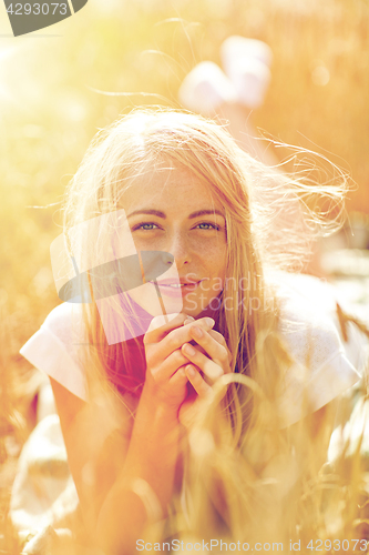 Image of happy woman or teen girl lying in cereal field