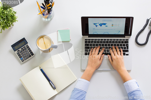 Image of hands of businesswoman working on laptop at office