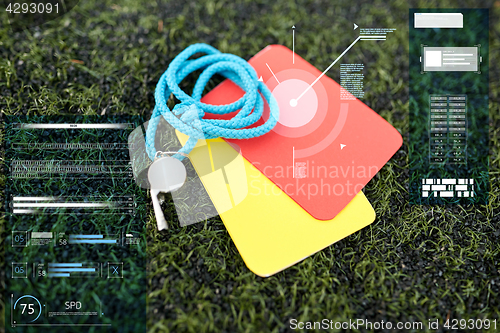 Image of whistle and caution cards on football field