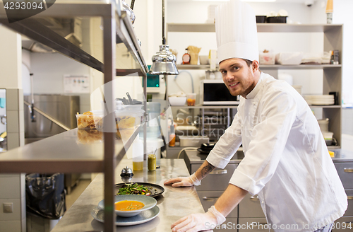 Image of happy male chef cooking food at restaurant kitchen