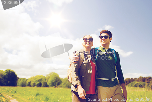 Image of happy couple with backpacks hiking outdoors