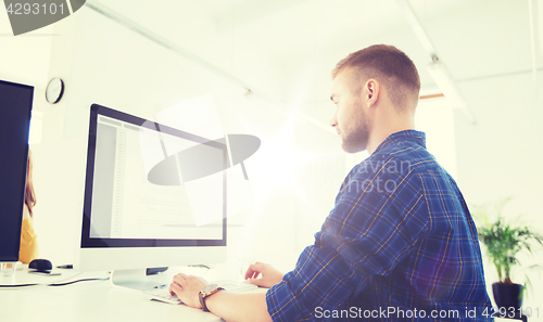 Image of creative man or programmer with computer at office