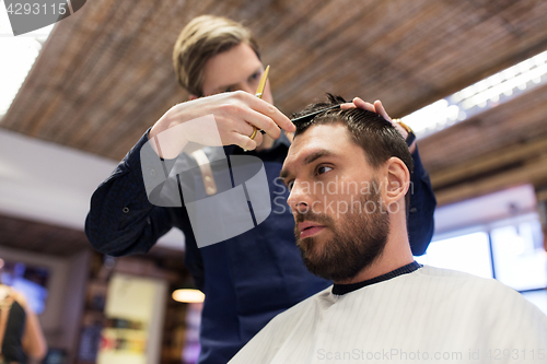 Image of man and barber cutting hair at barbershop