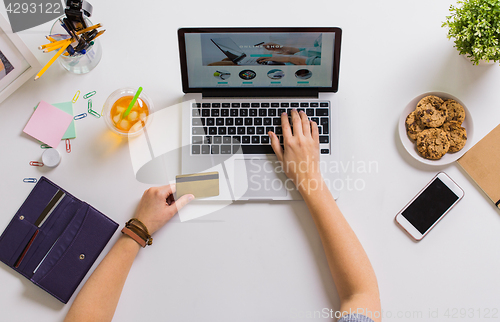 Image of hands with laptop and credit card at table