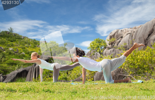 Image of happy couple making yoga exercises outdoors