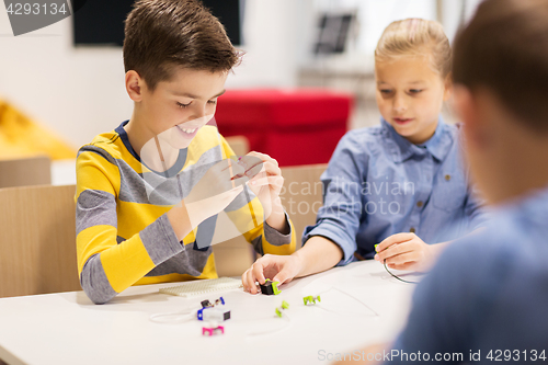 Image of happy children building robots at robotics school