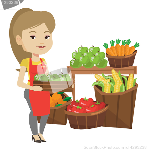 Image of Supermarket worker with box full of apples.