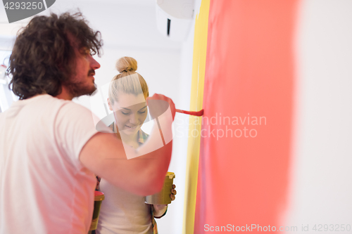 Image of couple painting interior wall